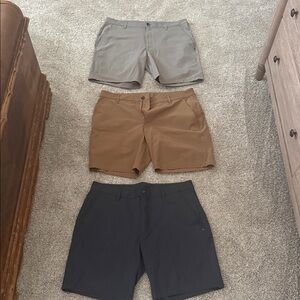 Vuori Men's Flat-Front Shorts in taupe, Brown, and Black